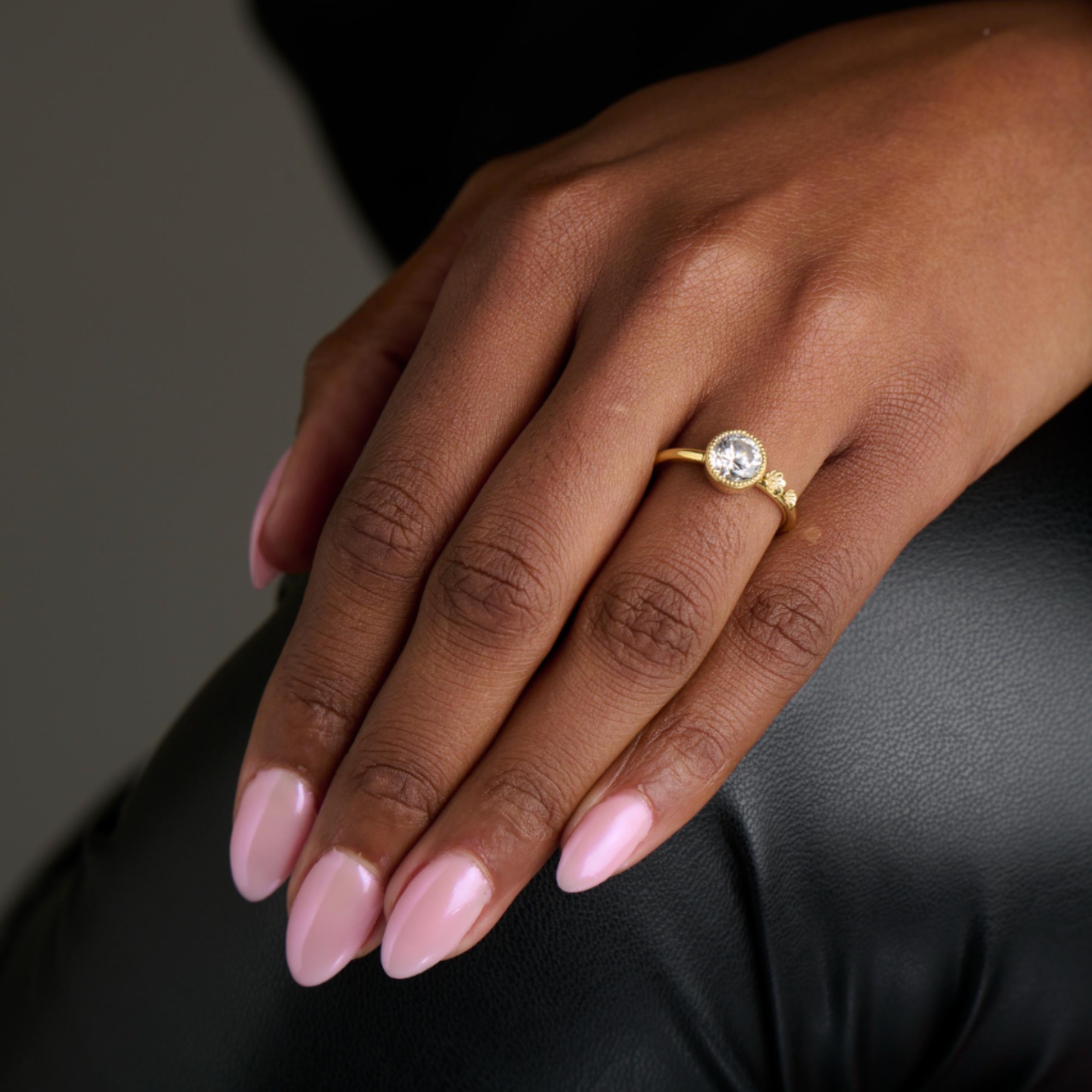 Round brilliant diamond ring with two assymetrical gold flowers